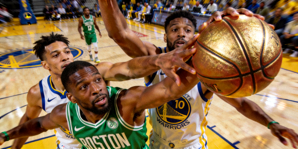 NBA季后赛波士顿凯尔特人队与金州勇士队球员在篮下争抢篮球的瞬间特写